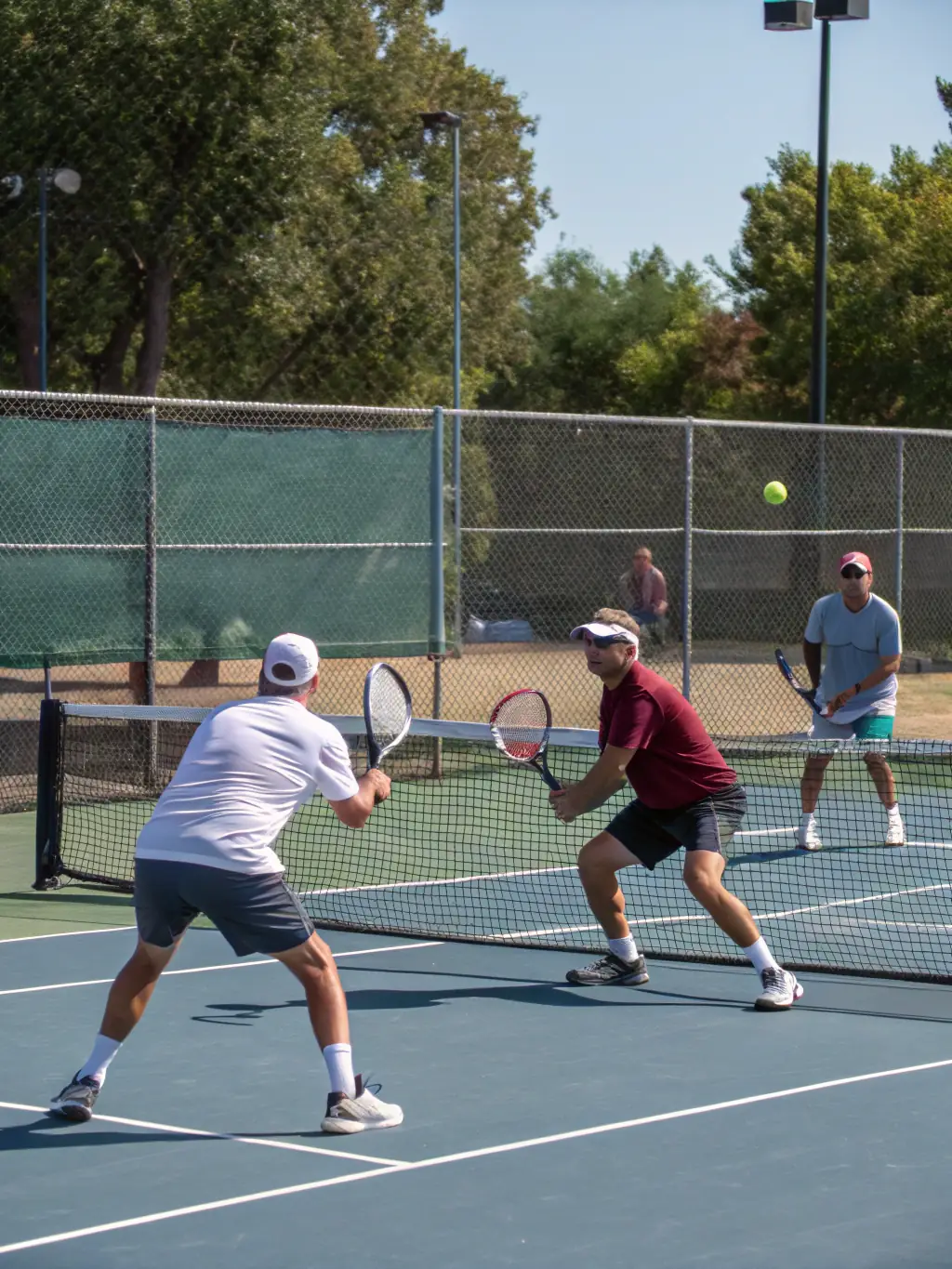 A group of senior players enjoying a friendly doubles match, emphasizing the social and recreational aspects of tennis at TCFD.